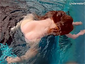 redhead Simonna displaying her assets underwater